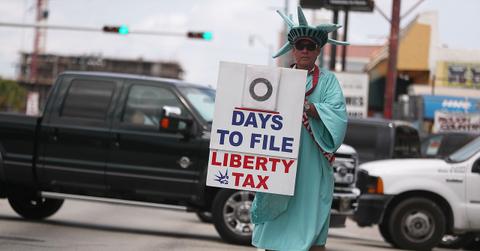 Man dressed in a Statue of Liberty costume holding a tax deadline countdown