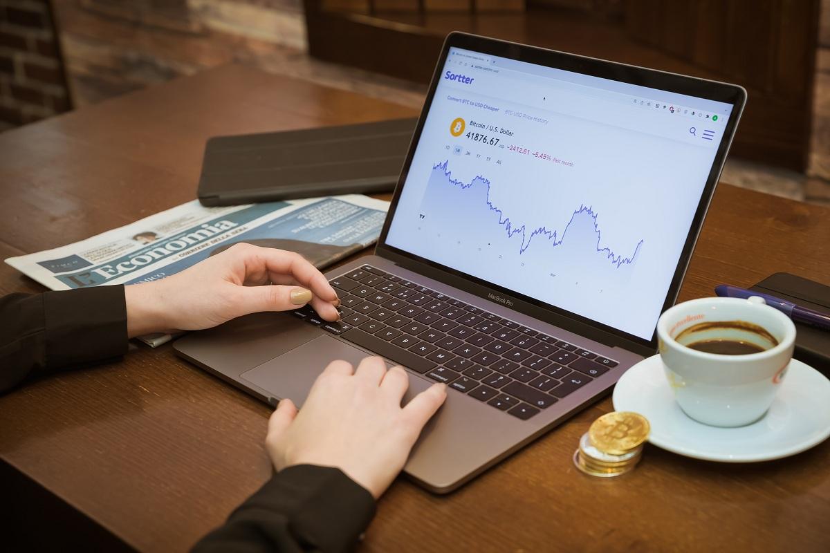 A person working on a laptop displaying a price chart