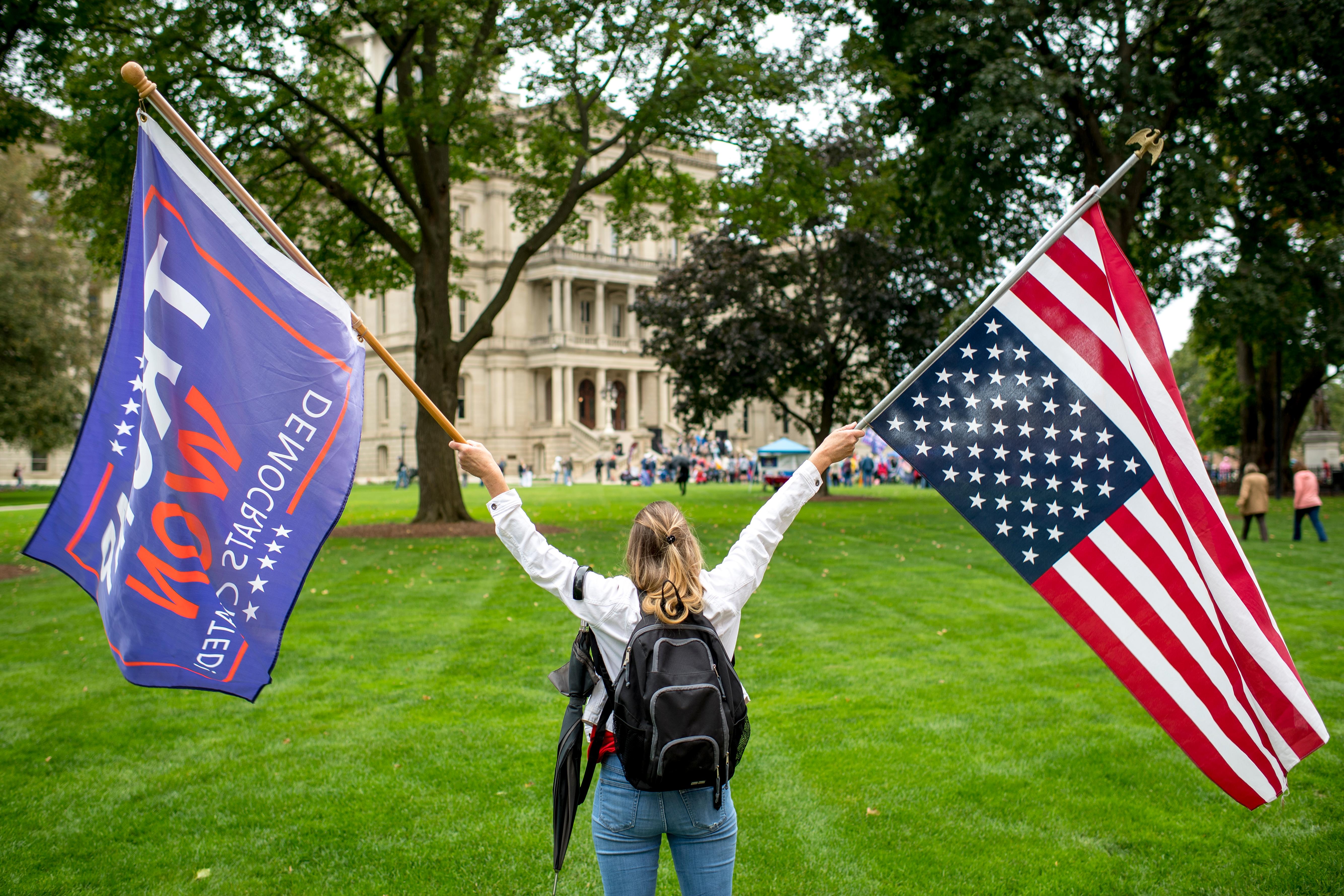 Woman carrying Trump flag and American flag