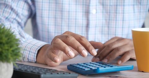 A man using a calculator to figure out tax write-offs