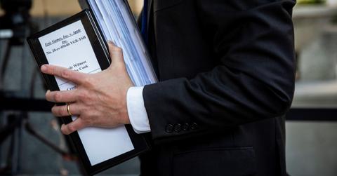 Lawyer holding Apple vs. Epic Games lawsuit evidence in binder