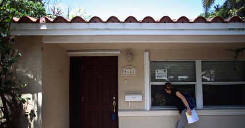 Person looking in window of foreclosed home