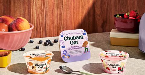 Chobani yogurt products on table beside fruit bowls