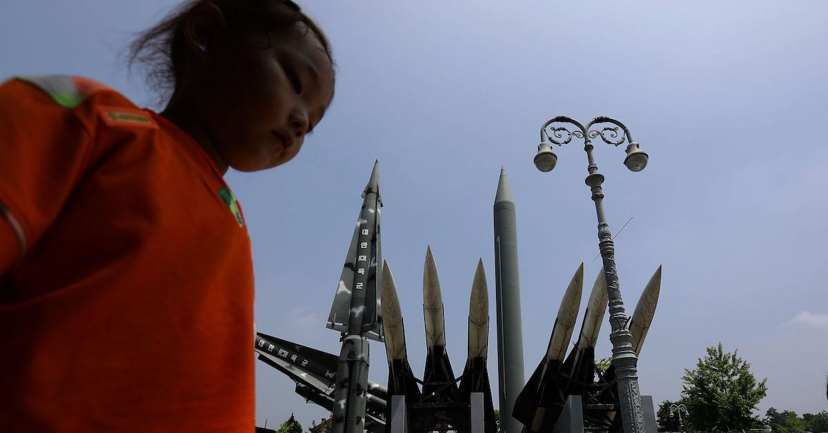 girl walks past missile replications