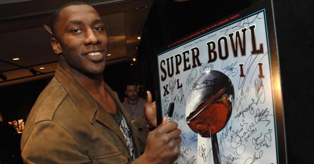 A young Shannon Sharpe signs a Super Bowl XLII poster.