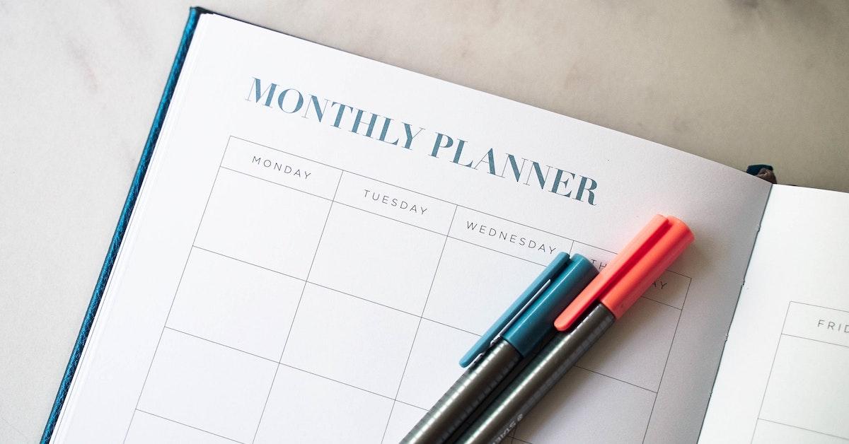 A monthly planner with colorful pens