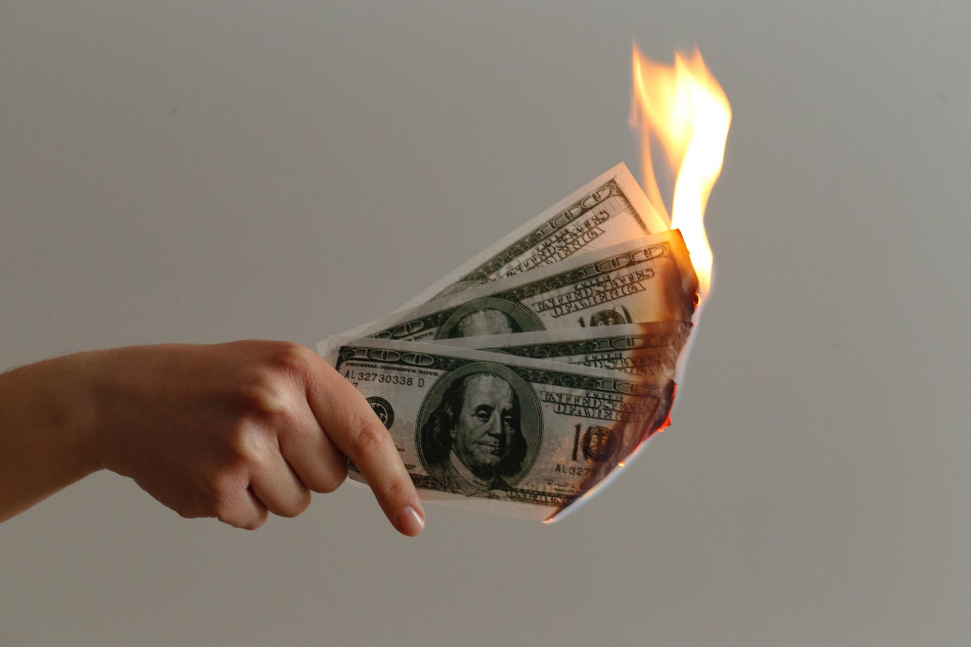 Burning money burning $100 USD bills 