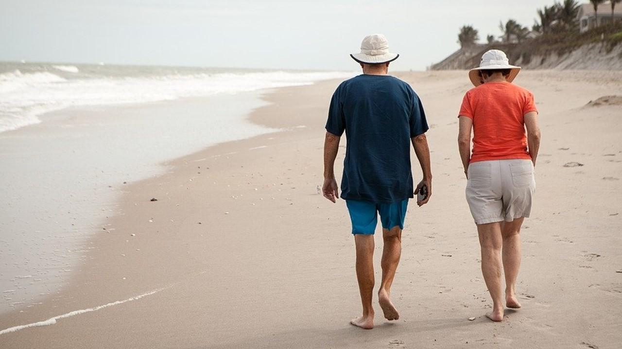 Older couple walking on the beach