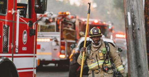A firefighter walking next to fire trucks