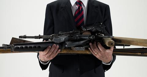 A businessman holding guns