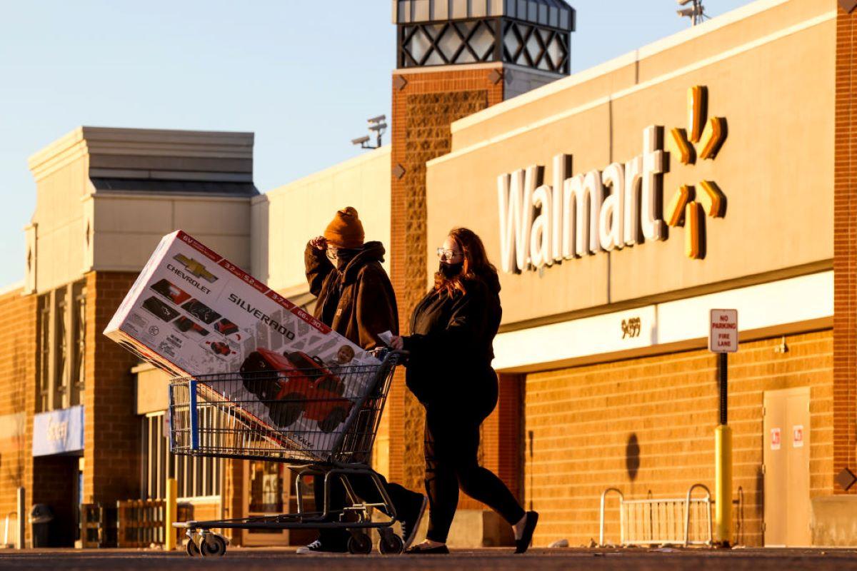 A couple walking out of Walmart with a large purchase