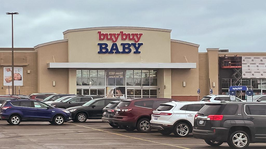 The outside of a buybuy Baby store with cars in the parking lot