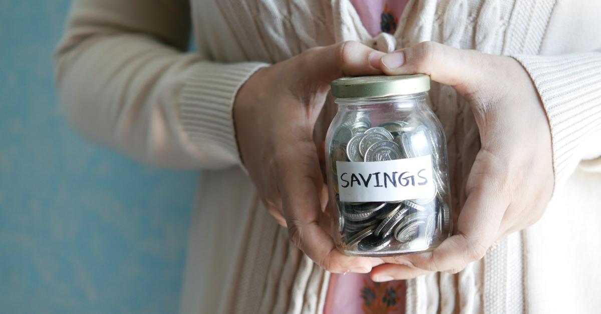 A woman holding a savings jar