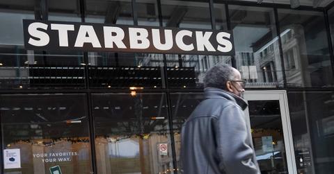 A man walking in front of a Starbucks