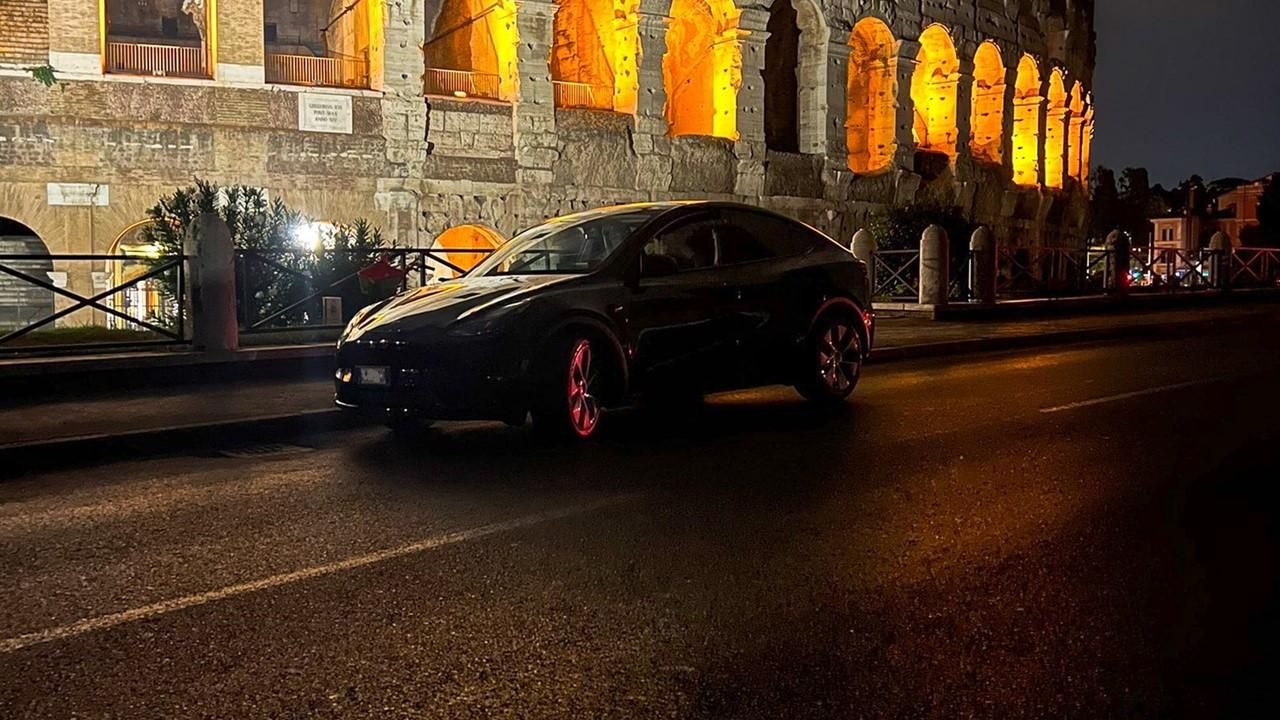 Tesla car driving past the Colleseum