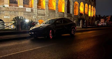 Tesla car driving past the Colleseum