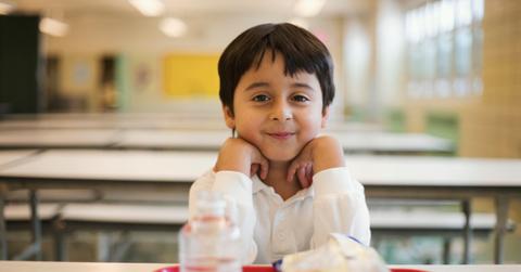 Child sitting at a table with a school lunch