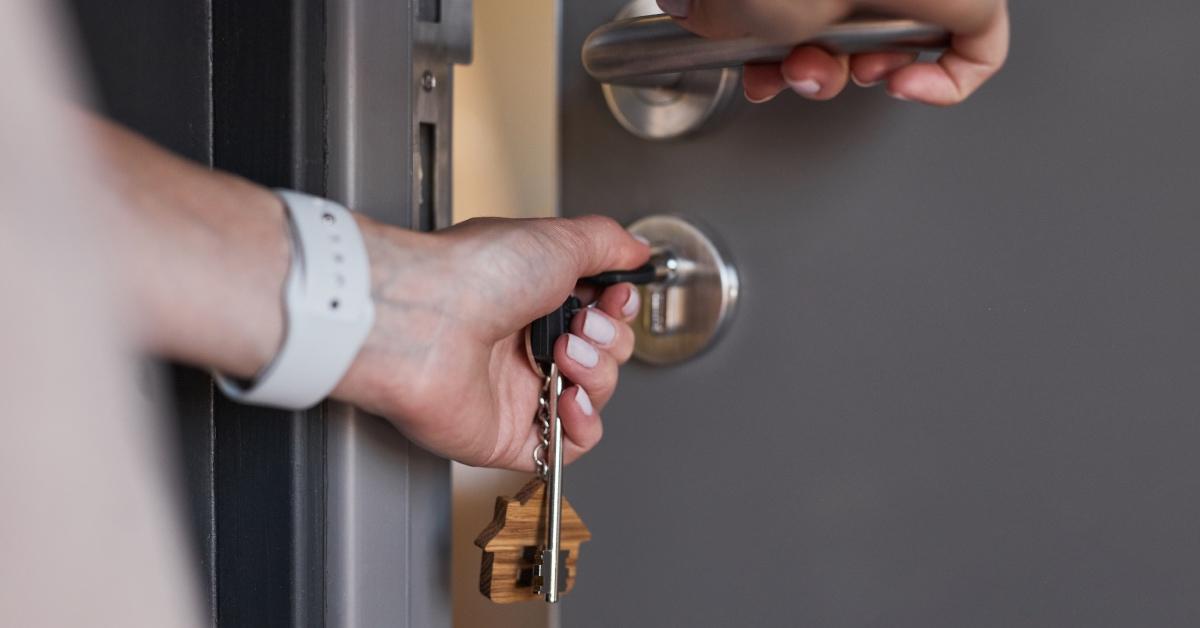 A person opening the door of their rental property 