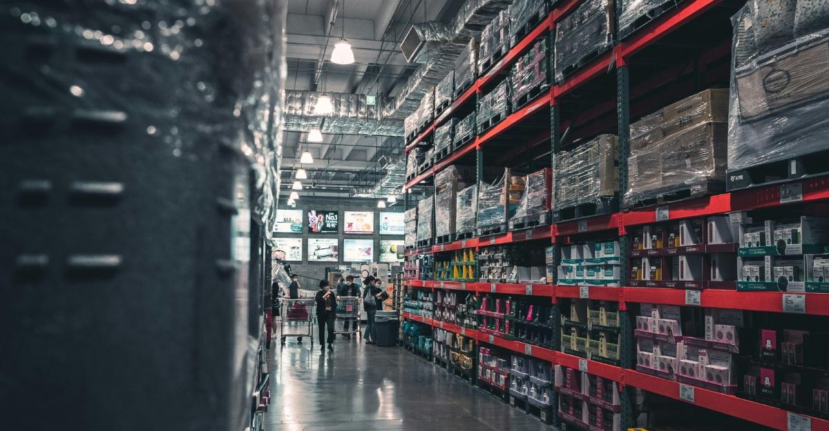 Stocked shelves in Costco are illuminated by bright lights.
