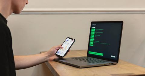 A person using a crypto exchange on a smartphone and laptop