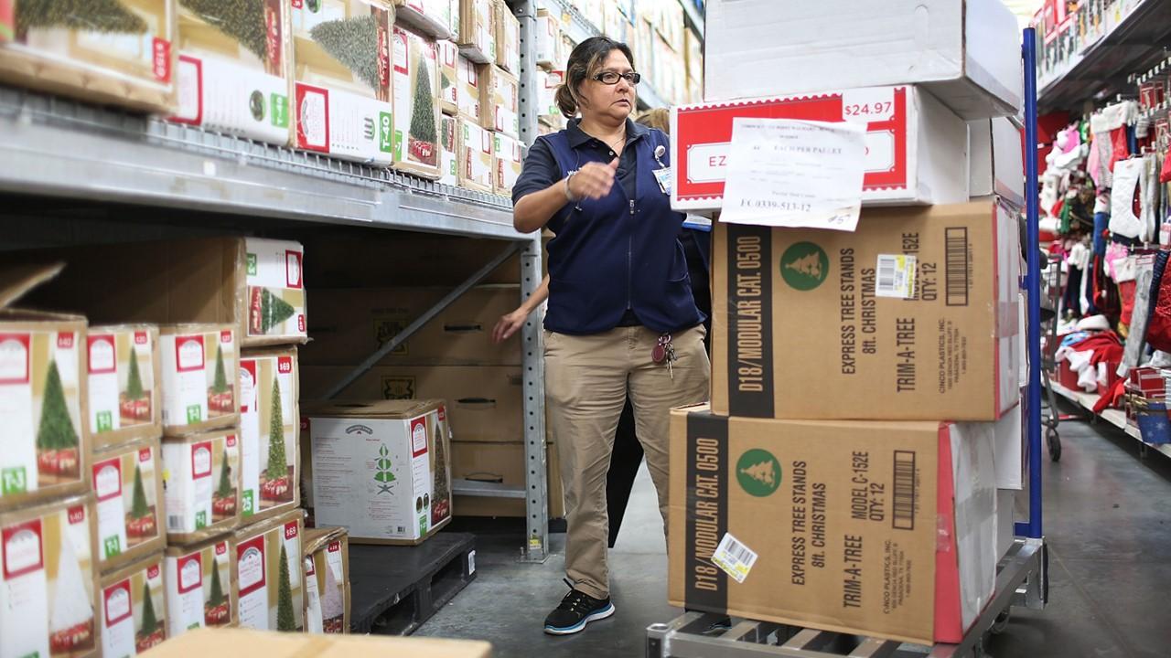 Walmart worker stocking Christmas trees for Black Friday