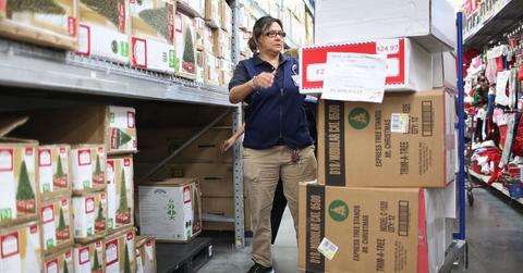 Walmart worker stocking Christmas trees for Black Friday