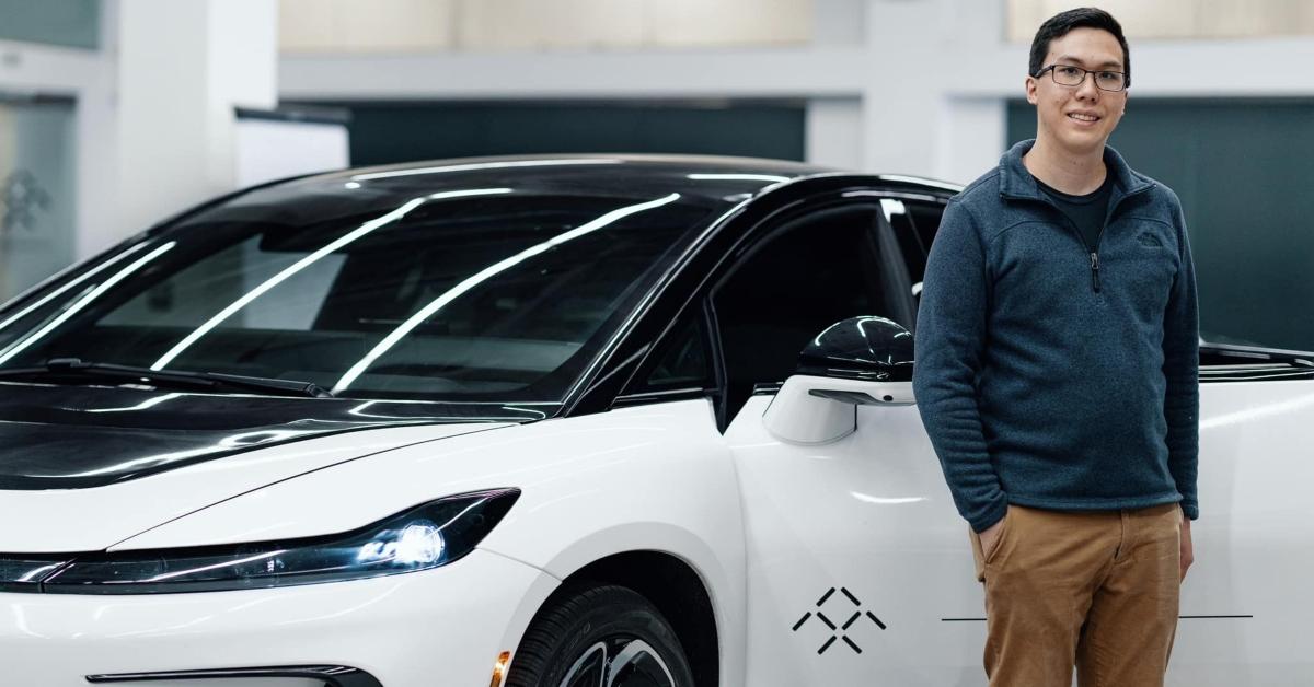 A person posing with a Faraday Future electric vehicle