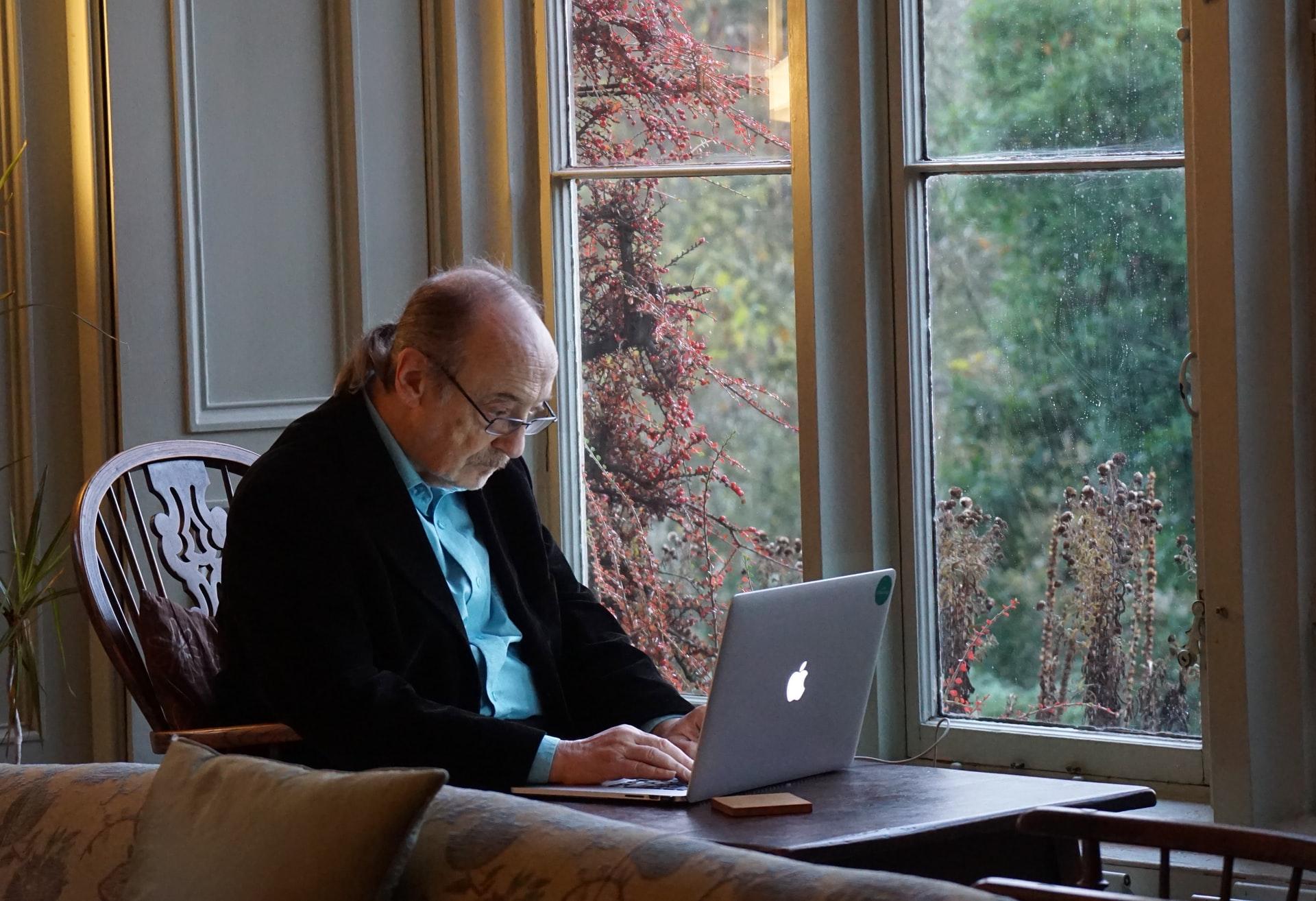 An elderly person using a laptop