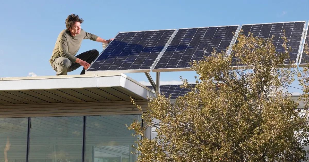 A man looking at the solar panels on the roof of his house.