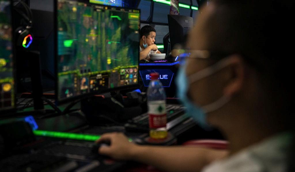 People gaming on computers wearing masks