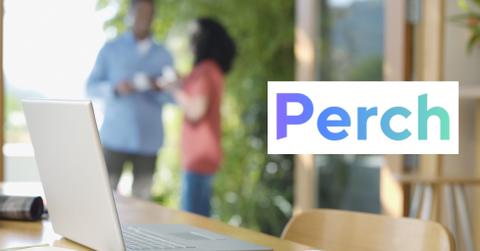 A laptop on a table, a couple talking in the background, and the Perch logo