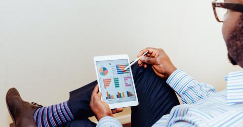 A person sitting on chair holding an iPad
