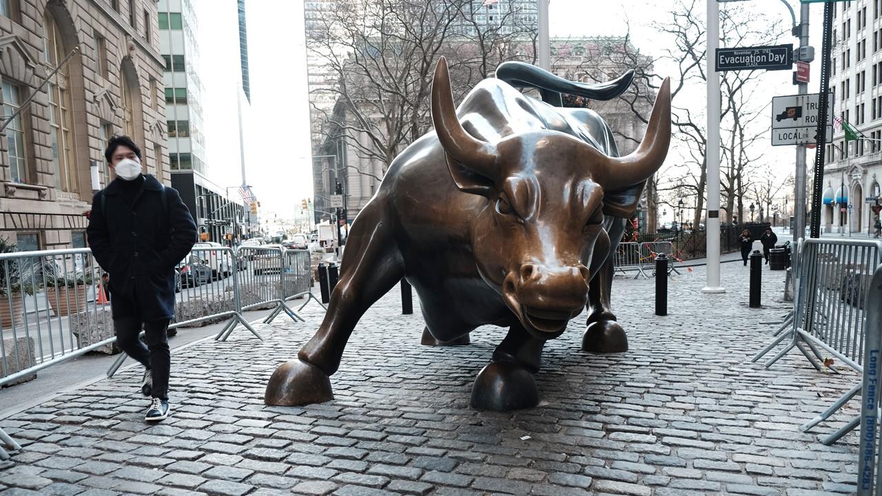 A man walking past the Wall Street Bull