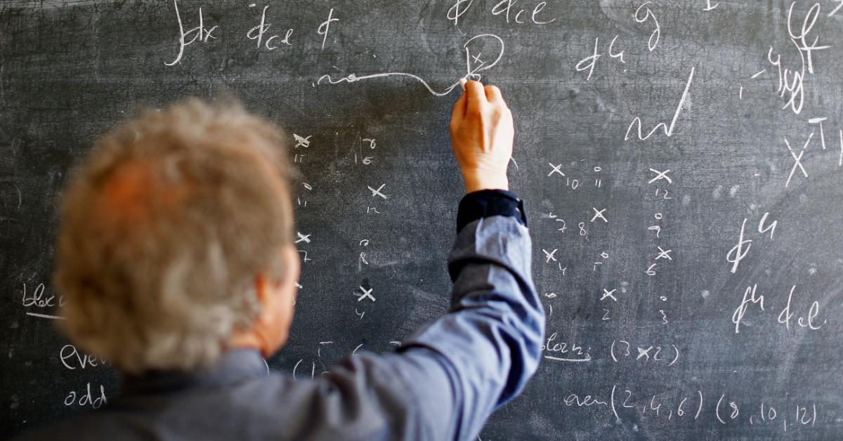 Scientists making notes on blackboard at CERN