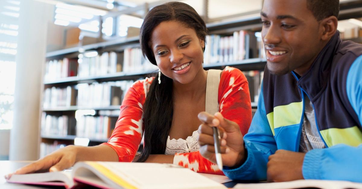 Two students study together in a library. 