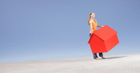 An illustration of a person carrying a red house