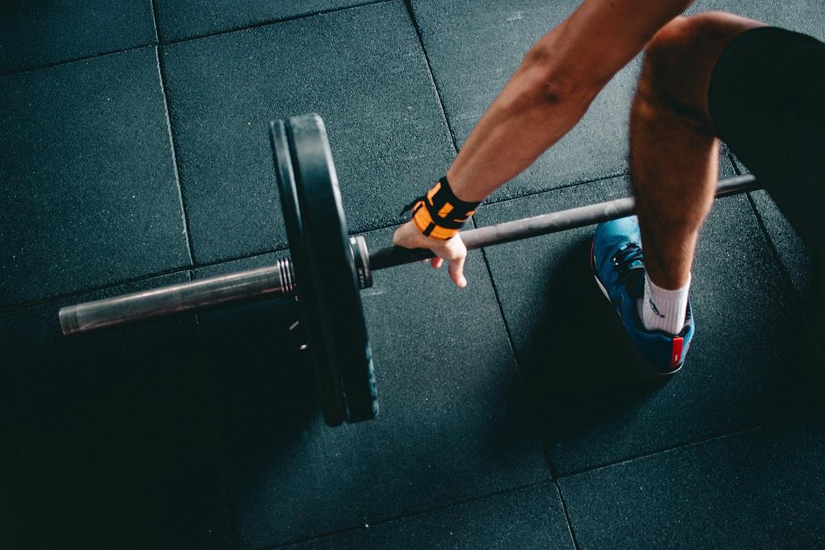 Person holding black barbell