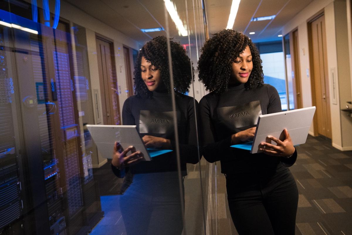 A professional Black woman with natural hair looking on a laptop