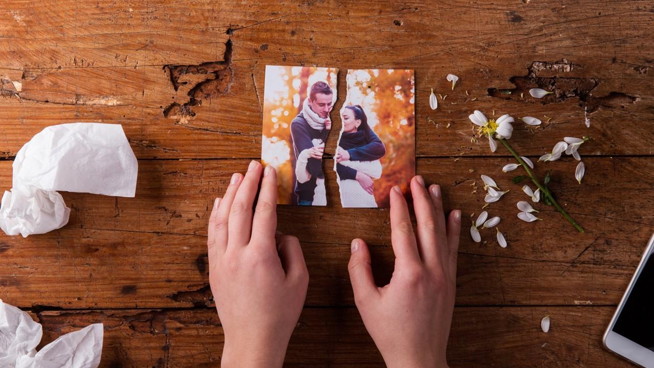 A woman looking at a torn picture