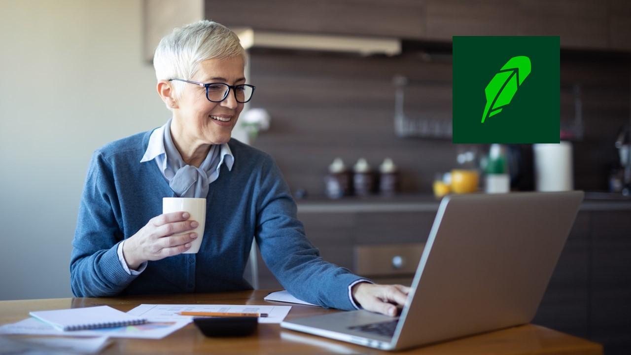 A woman looking on a laptop and the Robinhood logo