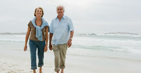A retired couple walking on the beach