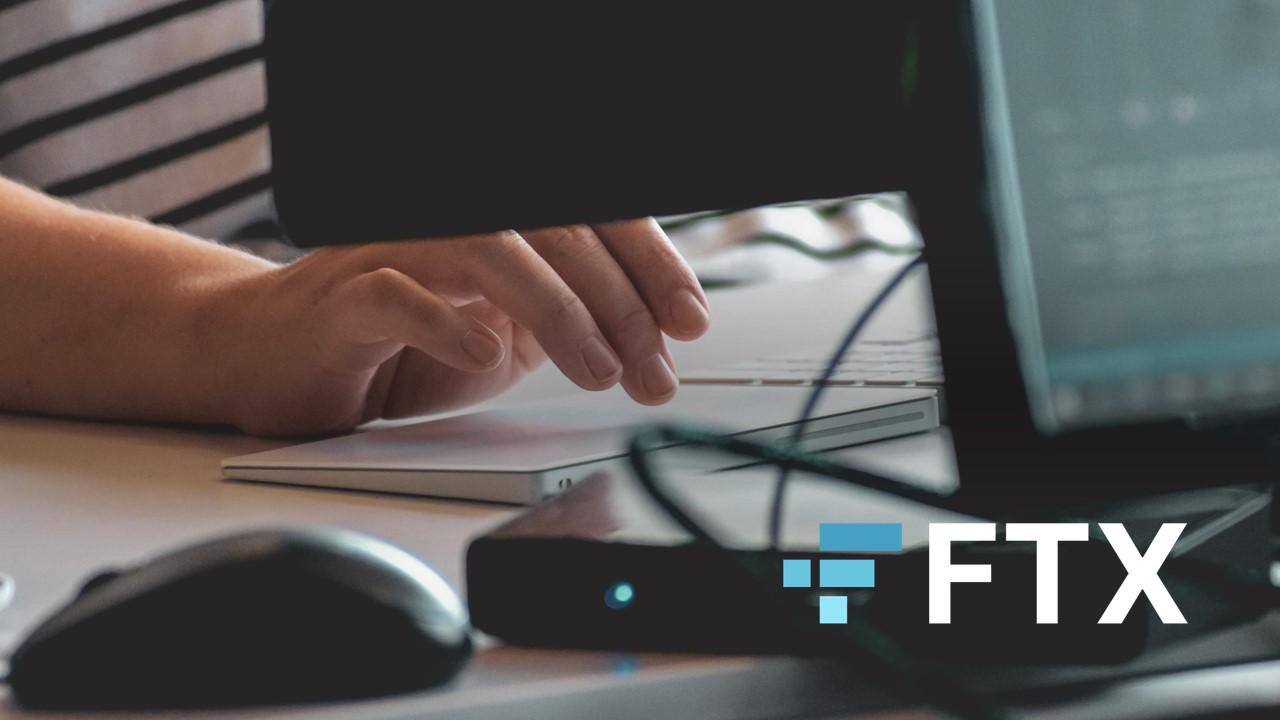 Person using computer, FTX Exchange white-and-blue logo