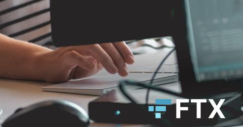 Person using computer, FTX Exchange white-and-blue logo