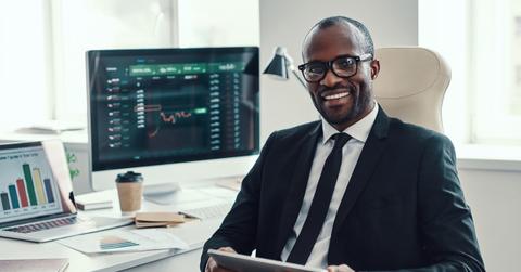 Man looking at data on a tablet and computer