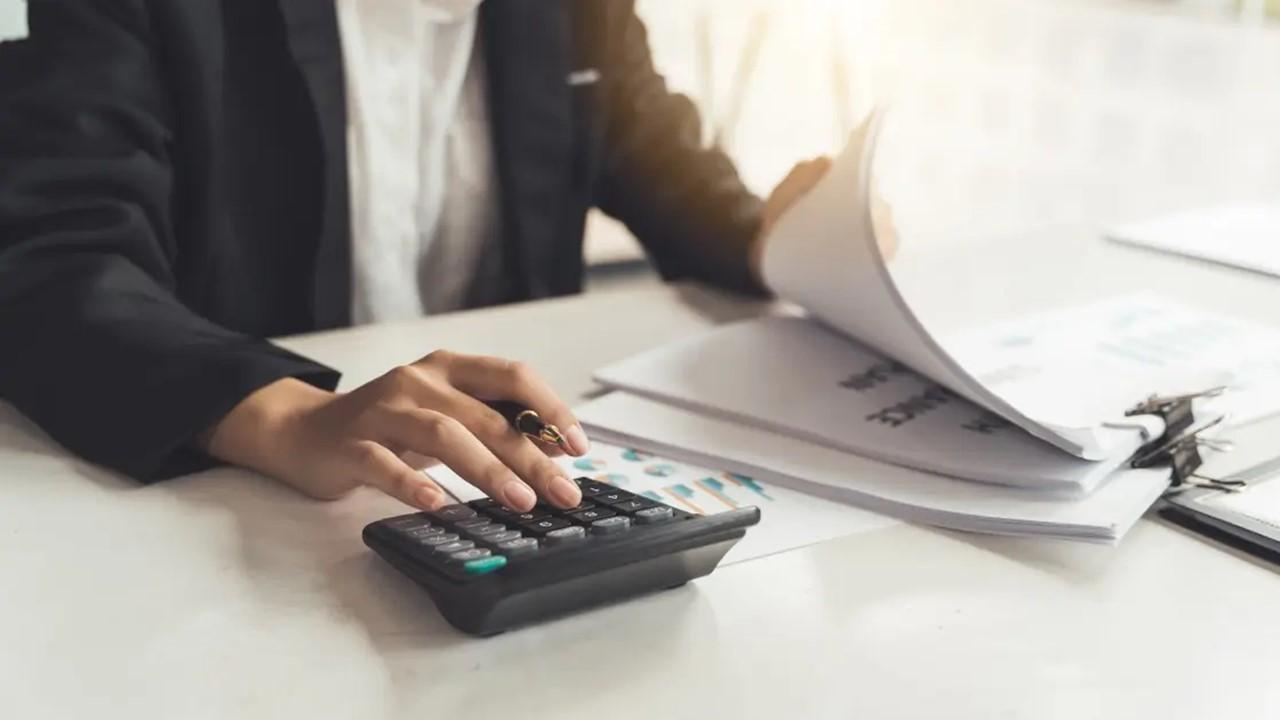 A woman using a calculator for tax audits