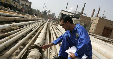 A worker gauges gas emissions from an oil pipe at the Daura oil refinery