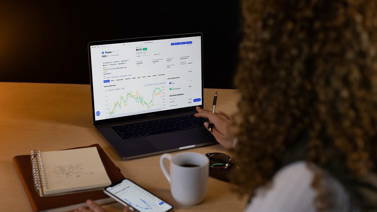 Woman looking at cryptocurrency chart on laptop