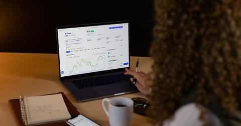 Woman looking at cryptocurrency chart on laptop