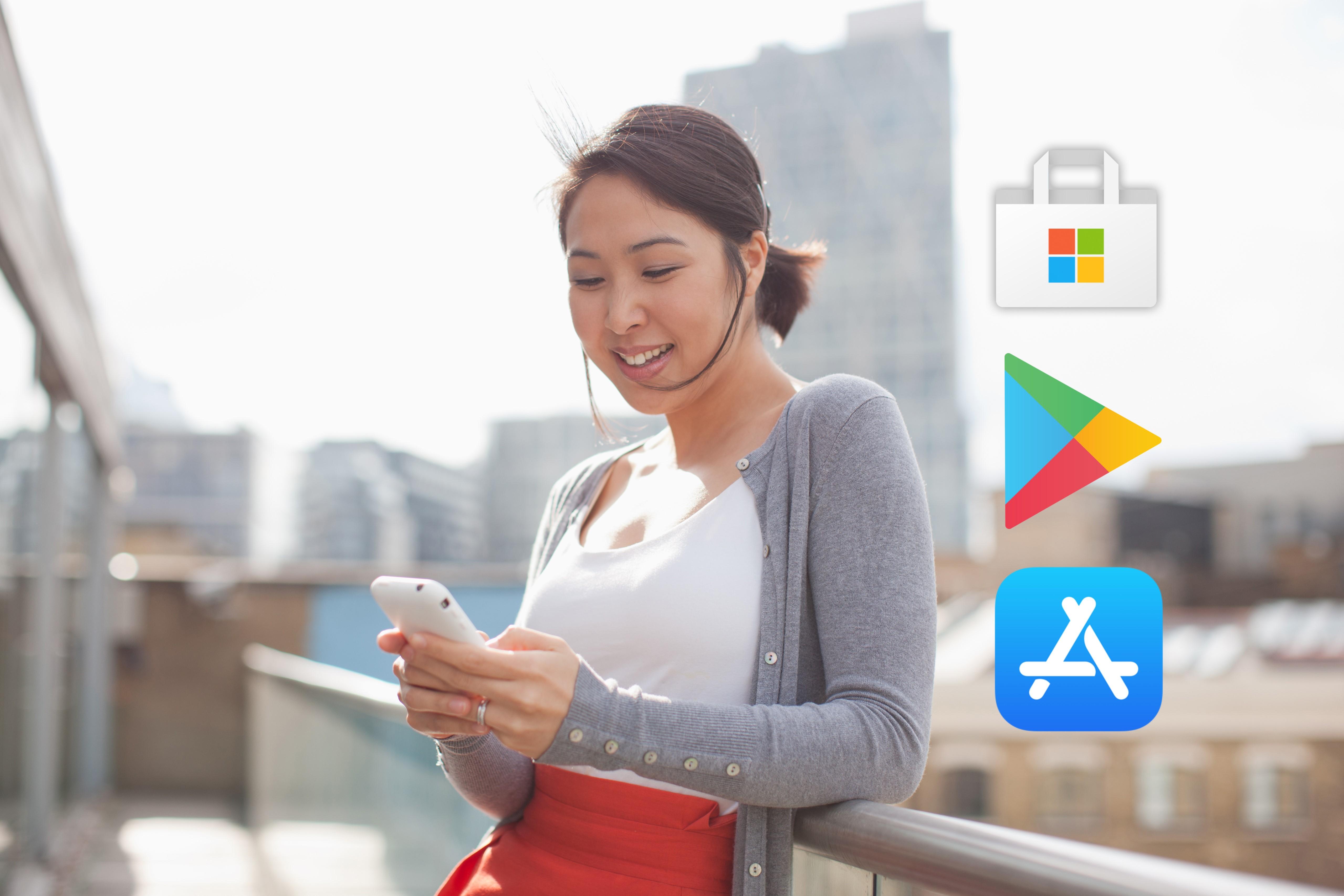 Apple App Store, Google Play, and Microsoft Windows Apps logos over woman looking at smartphone