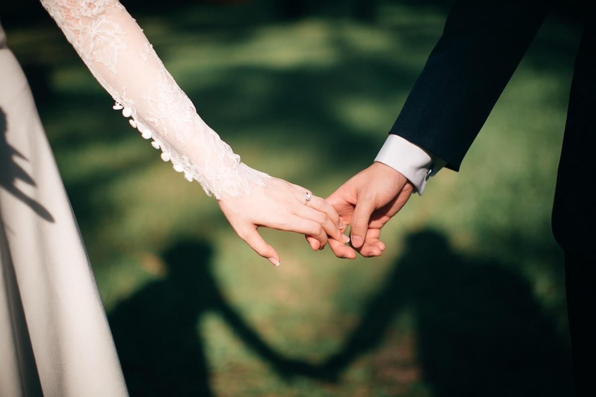 A couple holding hands on their wedding day